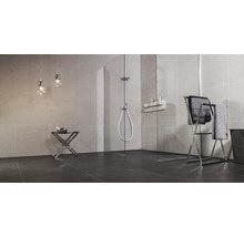 Modernes Badezimmer mit ebenerdiger Glasduschkabine, gefliesten Wänden, Handtuchständer und zwei Hängeleuchten in minimalistischem Design.