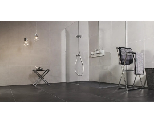 Modernes Badezimmer mit ebenerdiger Glasduschkabine, gefliesten Wänden, Handtuchständer und zwei Hängeleuchten in minimalistischem Design.