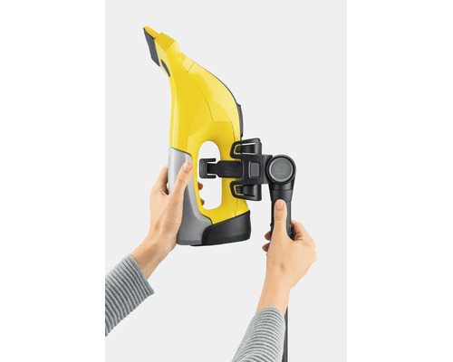 Un nettoyeur de vitres avec kit de rallonge fixé, tenu par des mains.