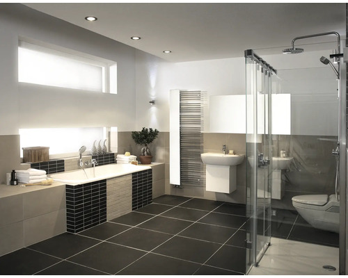 Salle de bain moderne avec baignoire, douche à l'italienne vitrée, lavabo, sèche-serviettes et carrelage au design épuré.