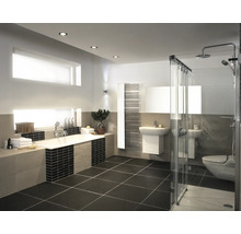 Salle de bain moderne avec baignoire, douche à l'italienne vitrée, lavabo, sèche-serviettes et carrelage au design épuré.