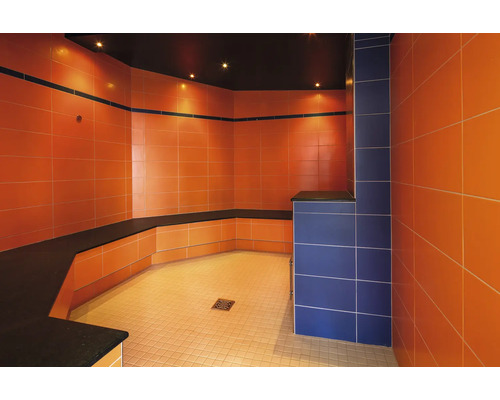 Hammam moderne avec des carreaux muraux carrés, un banc intégré et un siphon de sol.