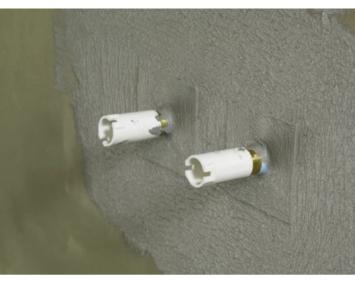 Zwei Wandanschlussstutzen fuer Sanitärinstallationen in einer verputzten Wand eingearbeitet