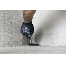 Artisan appliquant du mortier d étanchéité ou de l enduit dans le coin d un mur avec une truelle