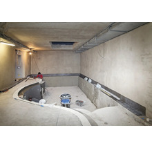 Chantier d une piscine intérieure avec des ouvriers effectuant des travaux d étanchéité sur les murs en béton.