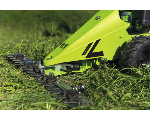 Vue détaillée de la barre de coupe d'une faucheuse à barre Zipper travaillant dans l'herbe haute.