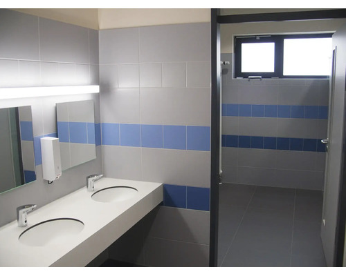 Modernes Badezimmer mit Doppelwaschbecken, Wandfliesen in zwei Streifen und funktionaler Beleuchtung.