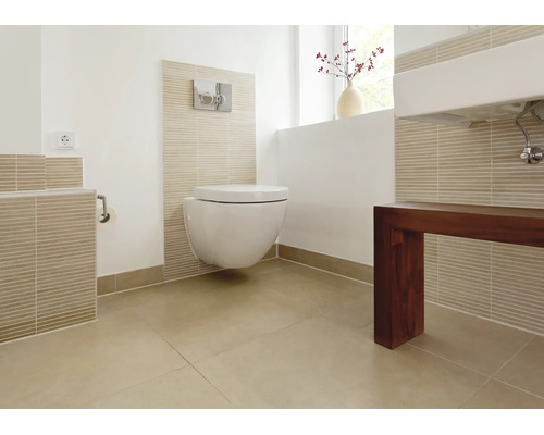 Salle de bains moderne avec toilettes suspendues et bâti support, carrelage dans des tons naturels et meuble vasque en bois foncé.