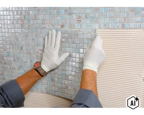 Artisan avec gants posant des carreaux de mosaïque en verre sur une surface murale enduite de colle à carrelage (Image AI modified or generated)