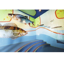 Décoration murale en mosaïque représentant des poissons et escalier incurvé dans un espace intérieur.