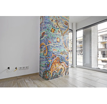 Une colonne ronde avec une mosaïque de verre colorée représentant des motifs sous-marins dans une pièce moderne avec carrelage et grandes baies.
