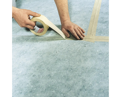 Eine Person klebt eine Fuge zwischen zwei Bauplatten mit tesa Klebeband ab.