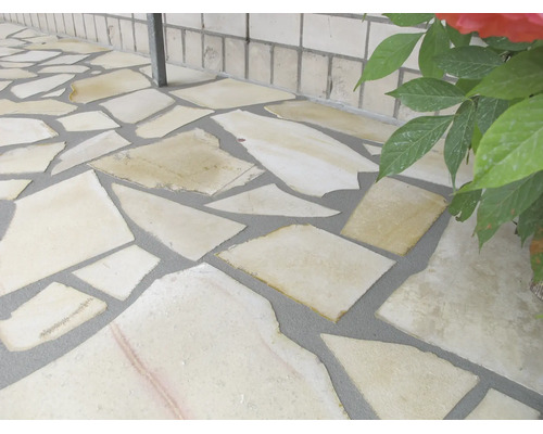 Revetement de sol en dalles de pierre naturelle irregulieres pour le jardin avec joints remplis.