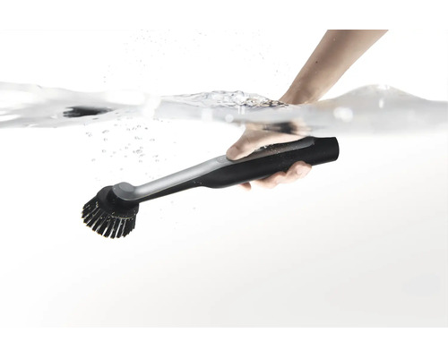 Une main tient une brosse de nettoyage électronique sous l eau.