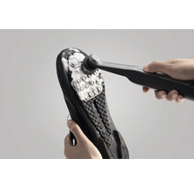 Brosse de nettoyage électrique pour nettoyer la semelle de chaussure avec de la mousse nettoyante.