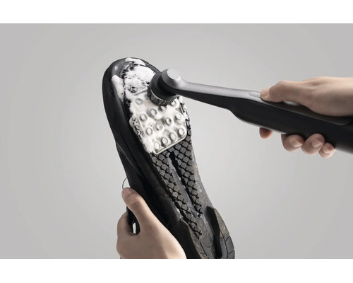 Brosse de nettoyage électrique pour nettoyer la semelle de chaussure avec de la mousse nettoyante.