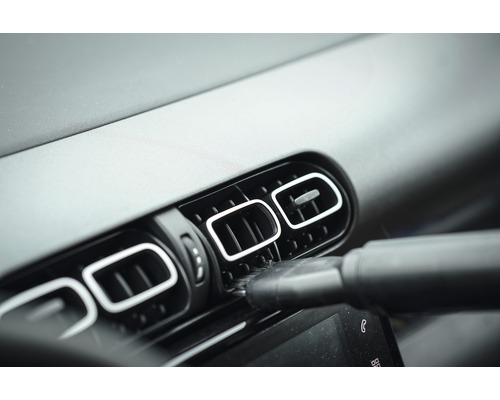 Nettoyage d''une ventilation de voiture avec un embout d''aspirateur