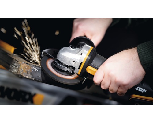 Une personne utilise une meuleuse d''angle pour meuler du métal, ce qui produit des étincelles.