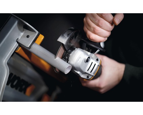 Une personne coupe un tuyau avec une meuleuse d''angle dans un atelier. Logo Worx.