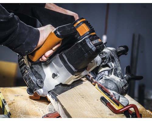 Une scie à onglet coupe une pièce en bois. Logo Worx.