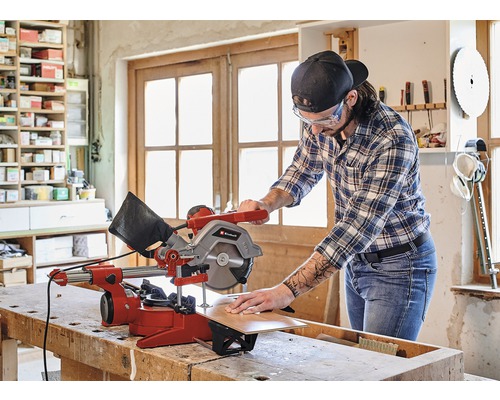 Mann arbeitet mit einer Einhell Kappzugsäge an einem Werkstück in einer Werkstatt.