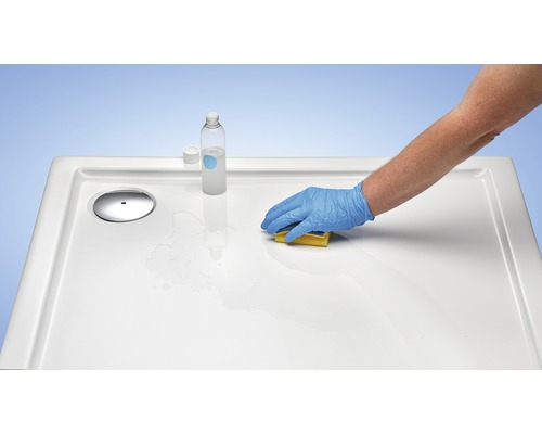 Nettoyage d''un receveur de douche avec une éponge et un produit de nettoyage