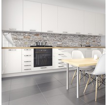 Scène de cuisine avec crédence aspect pierre, armoires blanches et table à manger