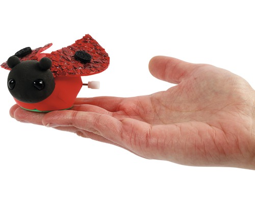 Auf einer Handfläche liegt ein Aufzieh-Marienkäfer