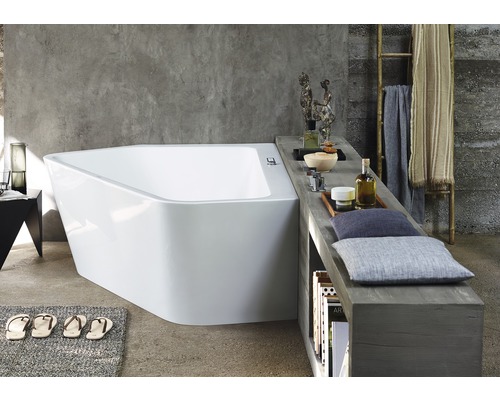 Salle de bain avec baignoire asymétrique, espace de rangement et éléments décoratifs pour une ambiance relaxante