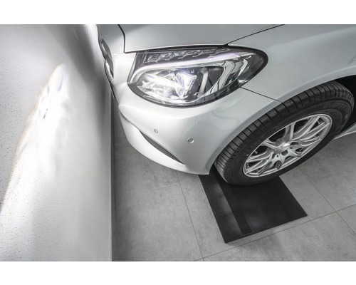 Silbernes Auto auf einer Parkmatte in einer Garage