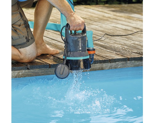 Pompe submersible pour eaux chargées Gardena tenue dans une piscine