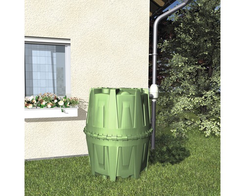 Grüne Regentonne im Garten neben einem Haus mit Dachrinne