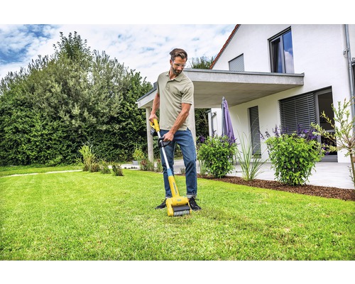 Un homme utilise un nettoyeur de bordure de pelouse dans le jardin.