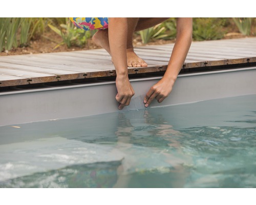 Une personne répare une bâche de piscine avec un kit de réparation de bâche
