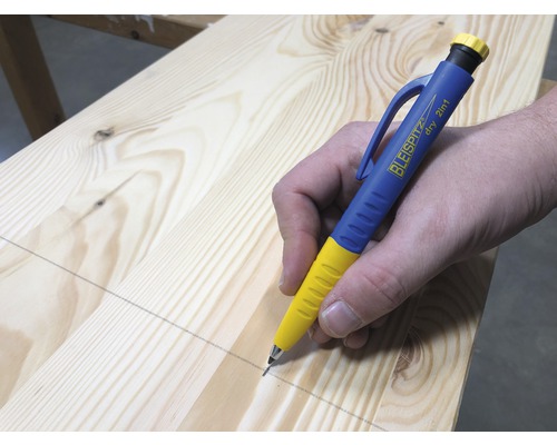 Une personne trace une ligne avec un crayon de menuisier sur une planche en bois.