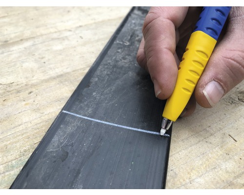 Une personne trace une ligne avec un stylo sur une pièce.