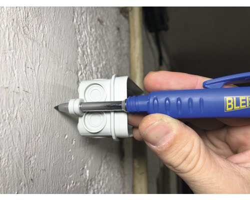 Un outil d''électricien est inséré dans une boîte de dérivation blanche.