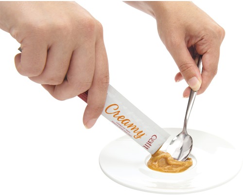 Friandise pour chat Cattit Creamy versée dans une assiette avec une cuillère