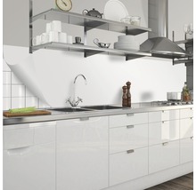 Cuisine moderne avec évier en acier inoxydable, robinetterie, façades blanches et étagères en acier inoxydable.