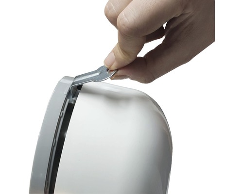 Hand, die einen Metallschlüssel in ein weißes Gehäuse einführt