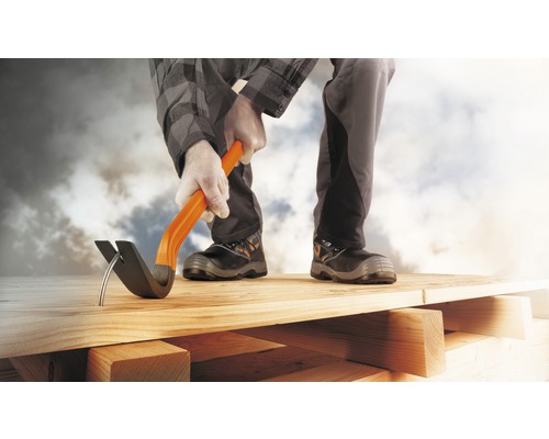 Mann entfernt Nagel mit Brecheisen aus Holzbrett