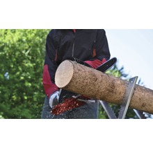 Homme sciant une bûche avec une tronçonneuse sur un chevalet