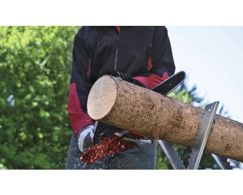 Homme sciant une bûche avec une tronçonneuse sur un chevalet