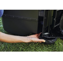 Detailansicht eines Rasenmähers mit Hand an einem Rad zur Höhenverstellung.