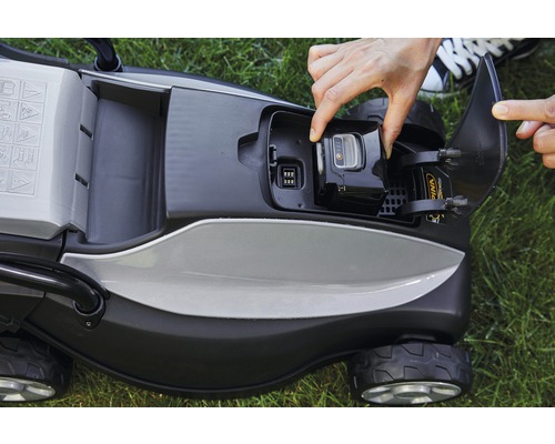 Aufsicht auf einen Rasenmäher mit einer Hand, die einen Akku einsetzt