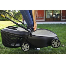 Eine Person bedient einen Rasenmäher auf einer Rasenfläche.