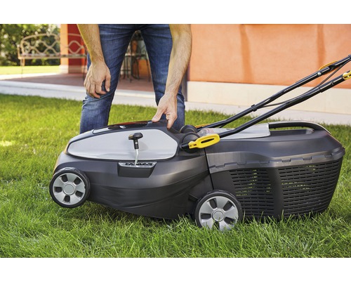 Eine Person bedient einen Rasenmäher im Garten.