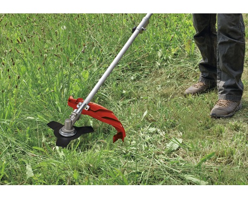 Detailaufnahme einer Person, die mit einem Rasentrimmer Gras schneidet