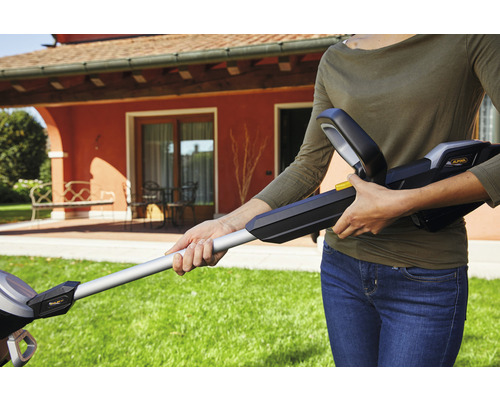 Frau bedient Akku-Heckenschere im Garten.