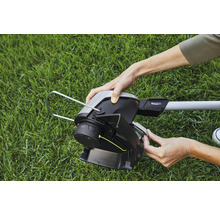 Nahaufnahme einer Person, die einen Rasentrimmer bedient.